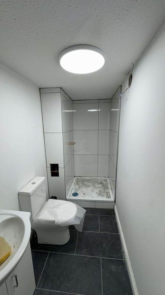 En-suite shower cubicle tiling underway