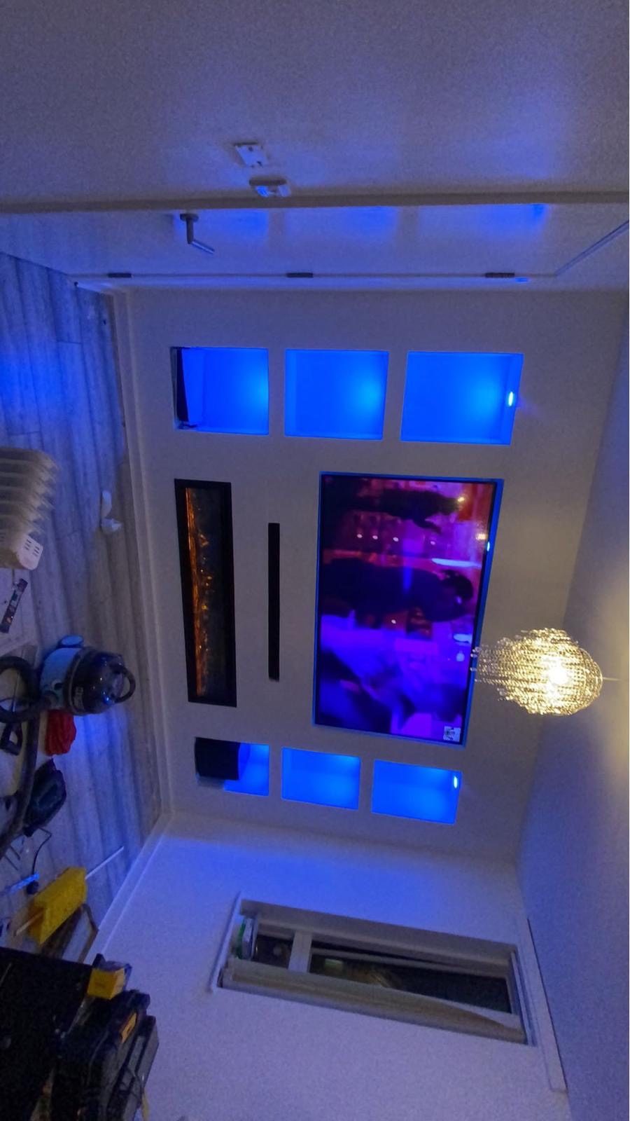 LED-lit media wall niches with recessed TV, angled view