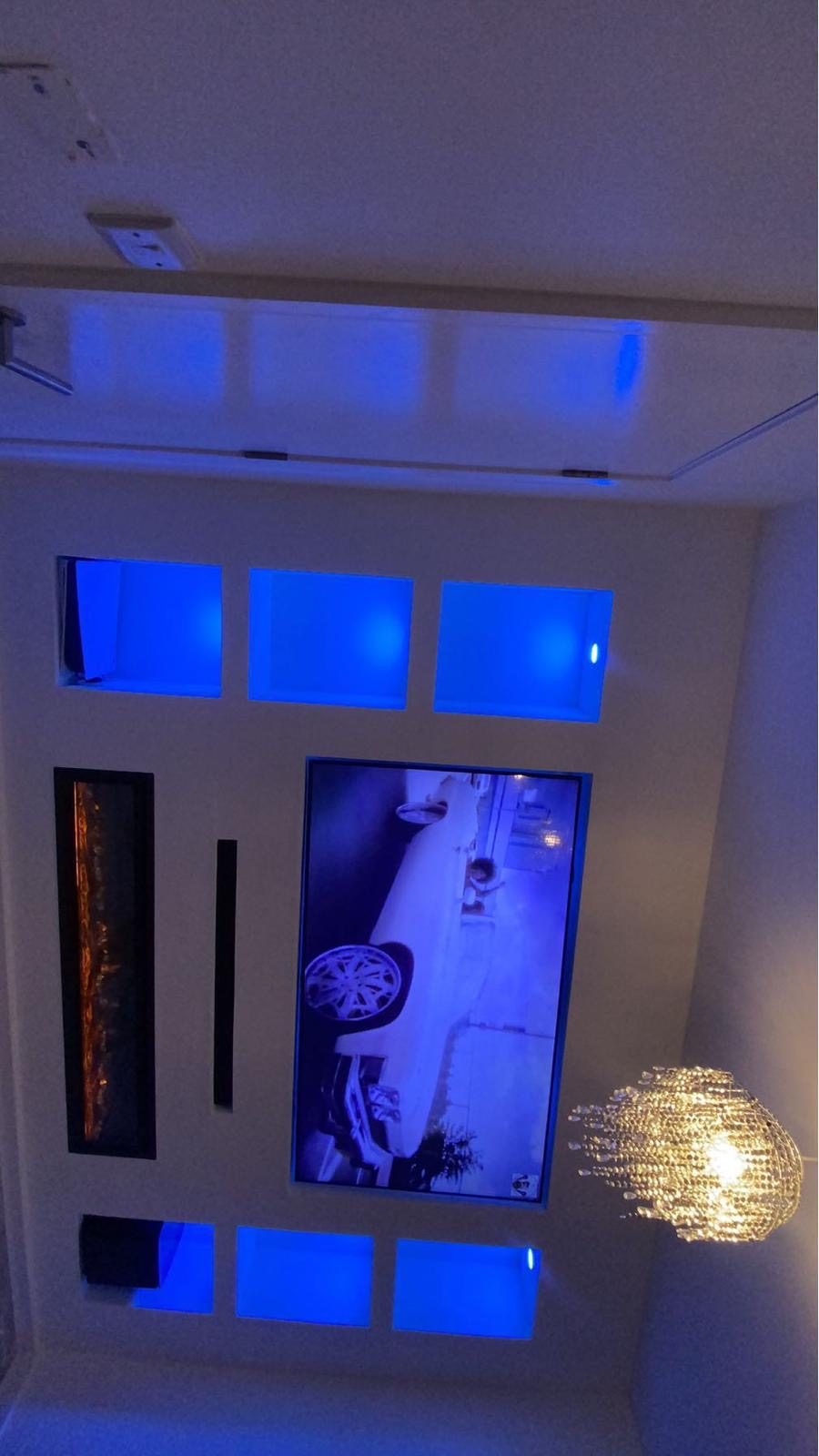 Blue LED media wall niches with integrated fireplace and TV